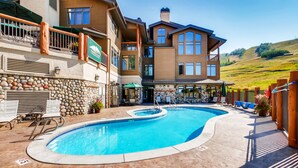 A large, multi-story building with a swimming pool and outdoor seating area.