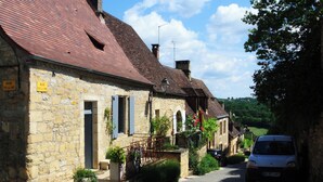 Eine enge Straße gesäumt von Steinbauten, einige mit sichtbaren Schildern, die Touren anbieten.