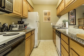 Enjoy cooking in this well-equipped kitchen with a granite countertop, stainless steel stove, and coffee maker.