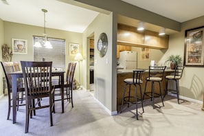 Enjoy a spacious living area with a dining table, kitchen, and bar, perfect for socializing and relaxation.