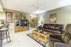 Relax in this inviting living room with a comfortable sofa, coffee table, and dining area.