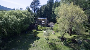 A multi-story building surrounded by lush greenery and trees. - River View Garden Resort (Monte Rio)