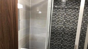 A bathroom with a shower, a sink, and tiled walls. - Résidence italien2  T3 (Abidjan)