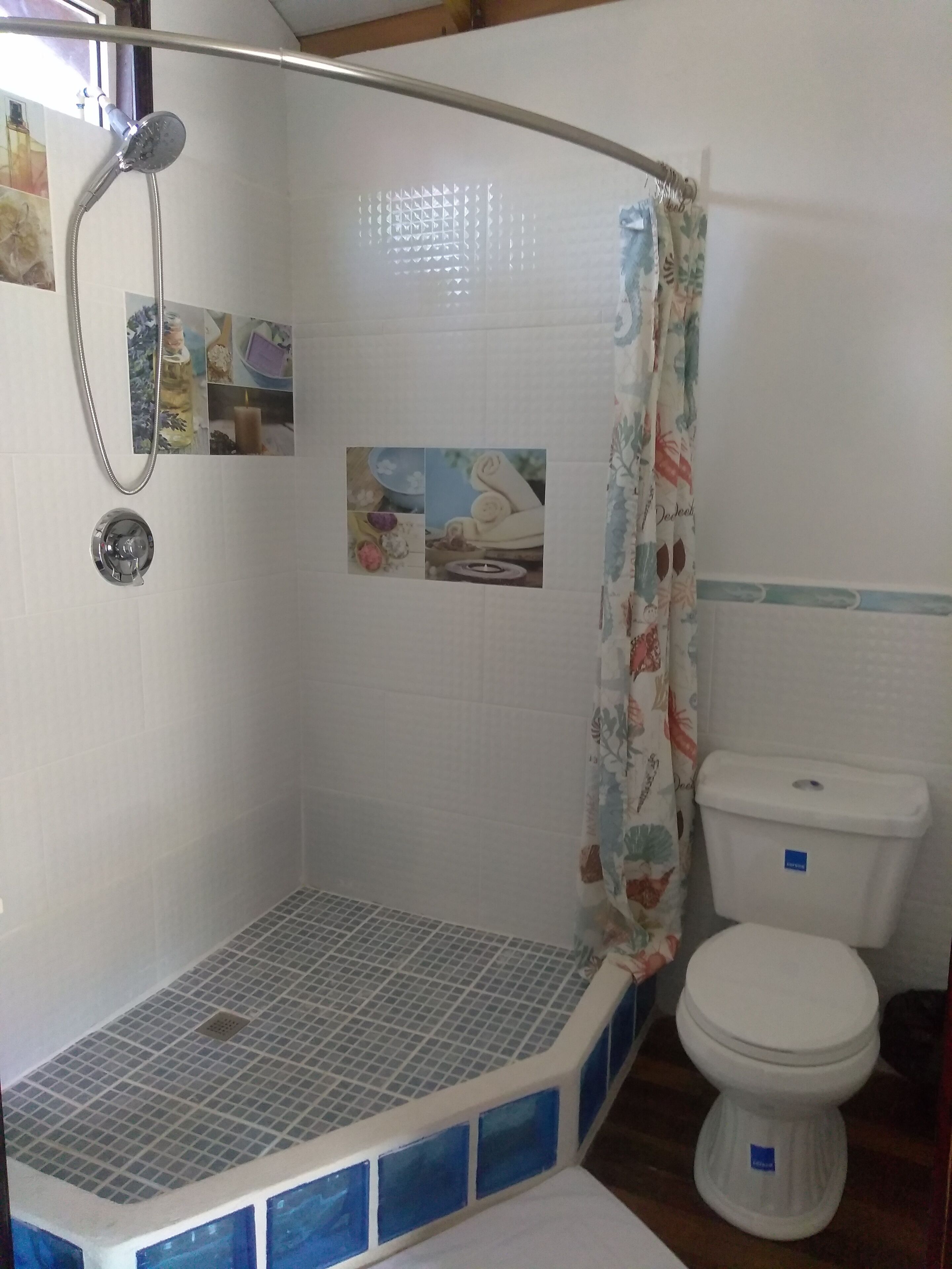A bathroom with a shower area, a toilet, and a tiled floor.
