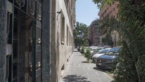 Una calle estrecha en la ciudad, con coches aparcados y edificios.