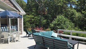 Una terraza con mobiliario exterior, incluyendo un sofá, sillas y una mesa.