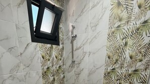 Un baño con suelo de mármol, lavamanos, inodoro y ducha.