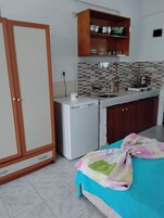 Frigorífico, placa de cocina, utensilios de cocina y mesa de comedor