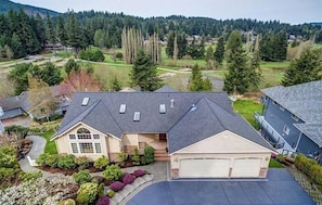 A residential house with a garage, a driveway, and a well-maintained lawn.
