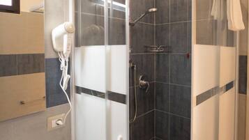 A modern bathroom with a glass-enclosed shower, a white sink, and a dark-toned vanity.