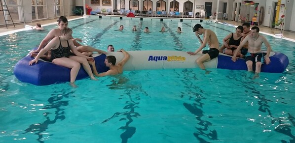 A swimming pool with people using inflatable tubes.