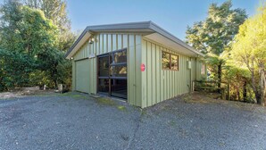 A small, single-story building with a sloped roof and a large sliding glass door. - Ruatotara - Pukawa Holiday Home (Pukawa Bay)