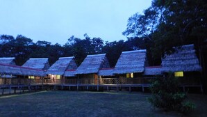 A row of thatched-roof huts with a wooden fence in the foreground. - Intillama Jungle Lodge (Fernando Lores)
