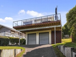 A two-story building with a balcony, a garage, and a fenced yard. - Lakewood - Omori Holiday Home (Omori)