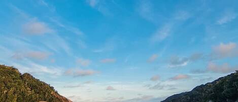 A calm body of water with a clear sky and distant landforms.