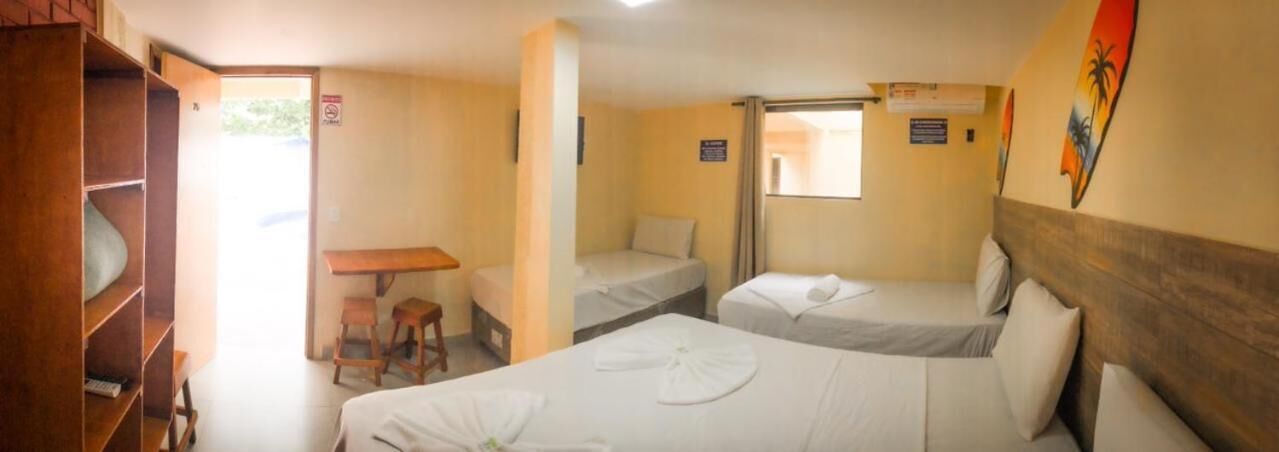 A hotel room with two single beds, a wooden desk, and a small table.