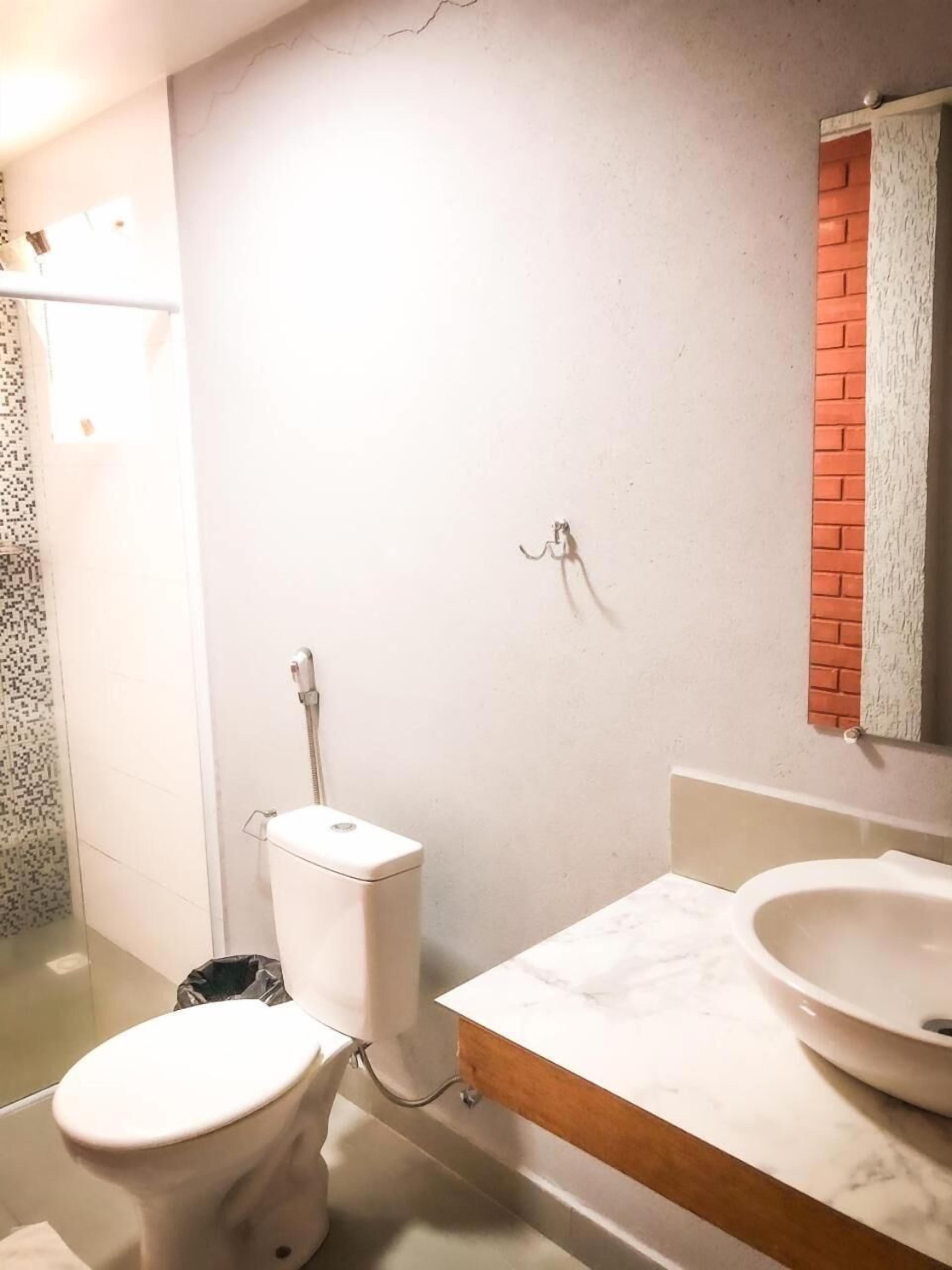 A bathroom with a toilet, a sink, and a shower.
