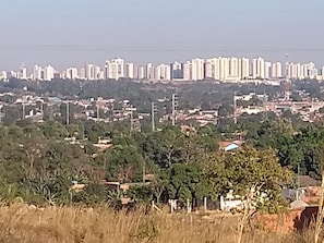 Un paisaje urbano con un conjunto denso de rascacielos al fondo y una mezcla de edificios residenciales y comerciales en primer plano.