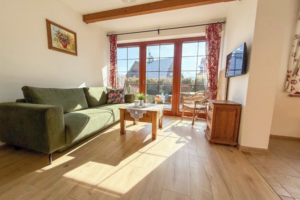 Sunny living room with green sofa and cosy space.
