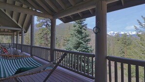 A wooden deck with a hammock and a view of a forest and mountains. - Eagles Rest:Mountain views>Huge home>Hiking (#23-ZONE3439) (Estes Park)