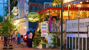 A restaurant with outdoor seating, a sign for take-out delivery, and a sign for beer and wine late night dining.