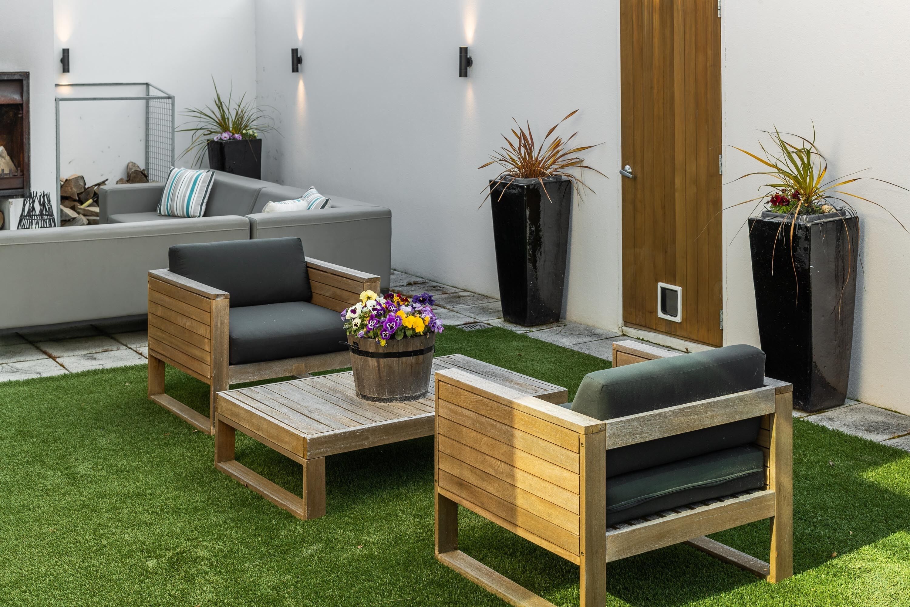 Un espace extérieur moderne, aménagé avec des meubles en bois et des plantes en pot.