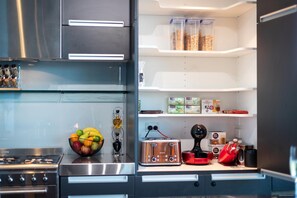 A modern kitchen with stainless steel appliances, a fruit bowl, a toaster, and a coffee maker. - Half Price sale April & May (Queenstown Hill)