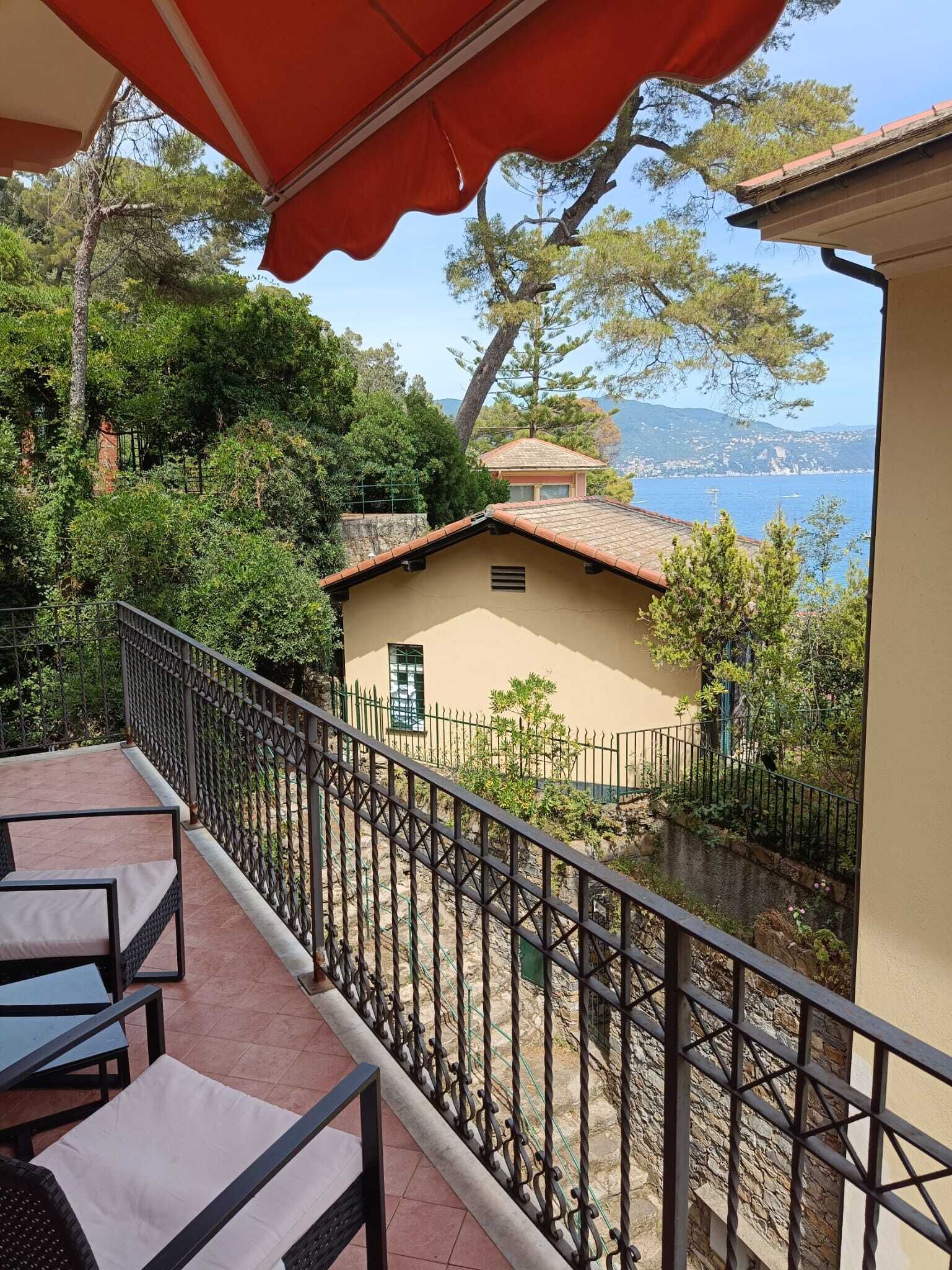 Ein Balkon mit Blick auf einen See und ein Gebäude mit einem Ziegeldach.