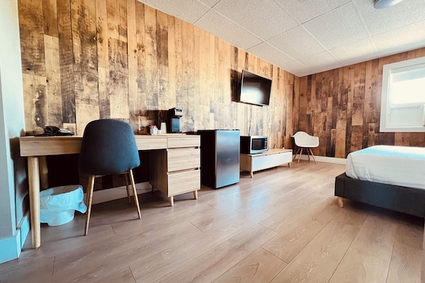 Escritorio, cortinas blackout y tabla de planchar con plancha