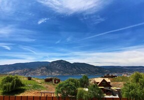 Propiedad frente al lago con cabañas, vista a las montañas y cielo despejado.