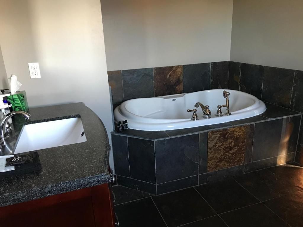 Une salle de bain avec une baignoire sur pieds, un lavabo et un meuble-lavabo.