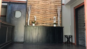 A reception area with a wooden wall, a sign reading "WESBERT WINERY," and two potted white orchids. - Wesbert Winery & Guest Suites (Penticton)