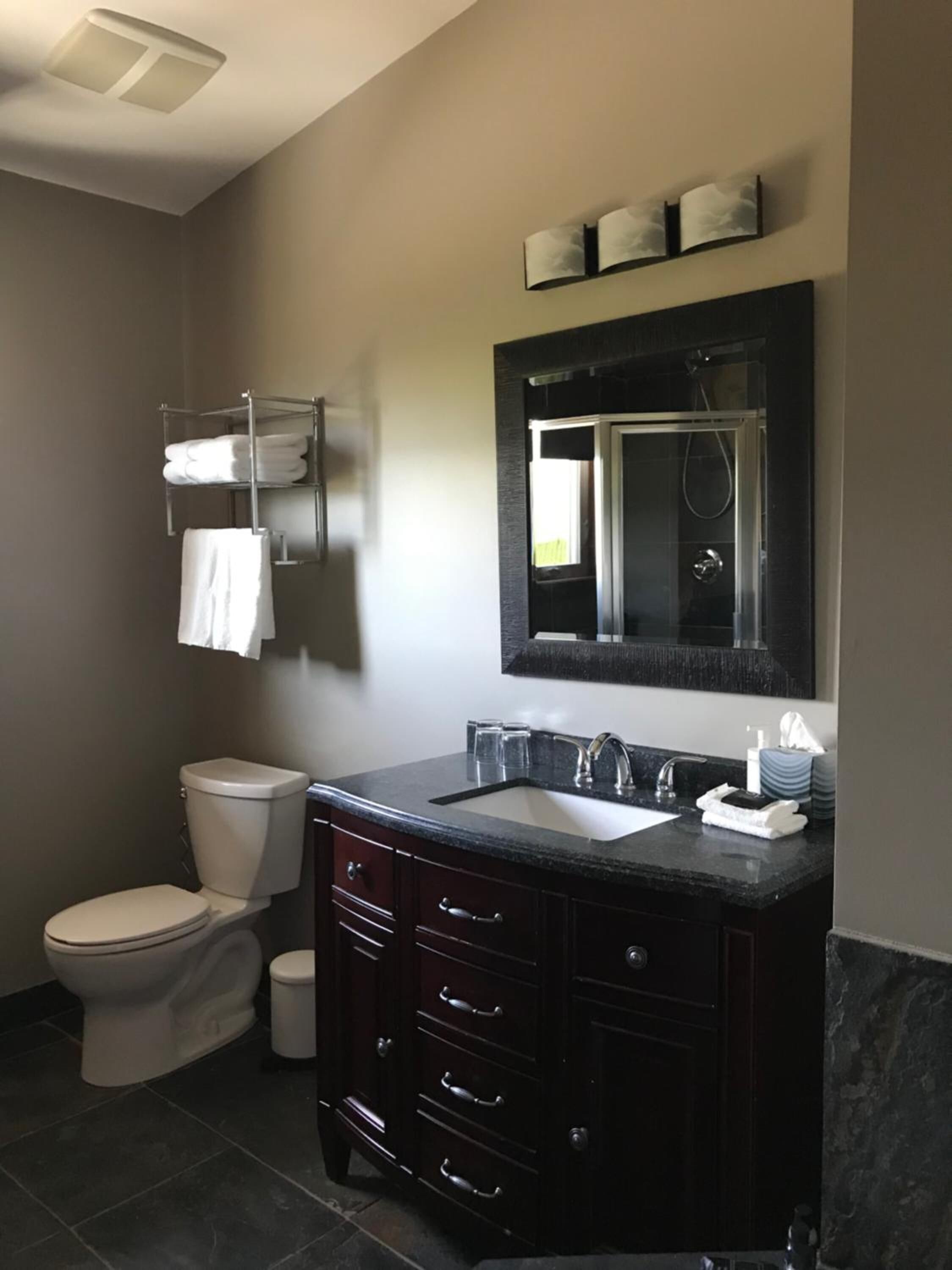 A modern bathroom with a toilet, sink, and vanity.