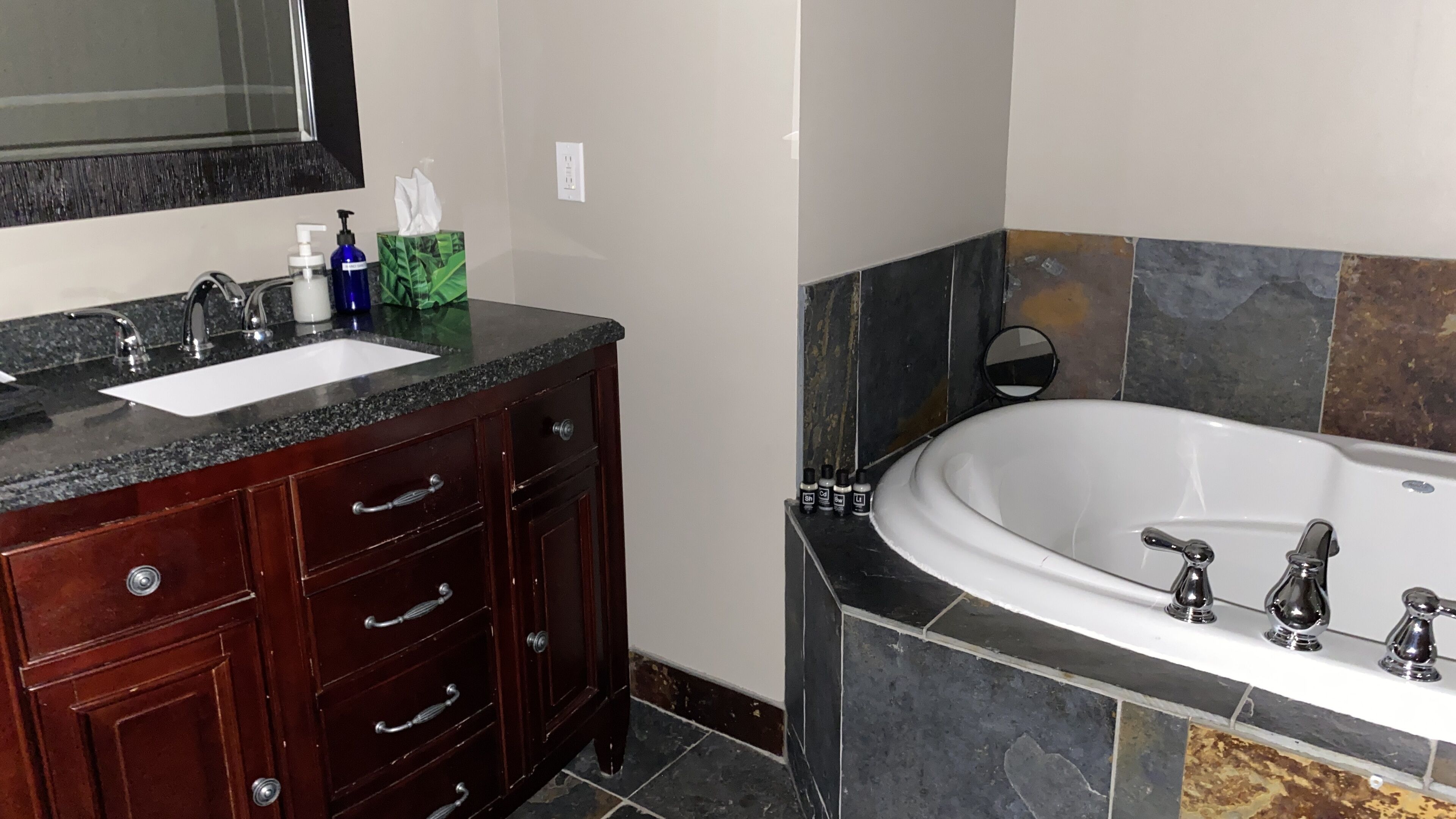 Un baño con tocador, lavabo y bañera.