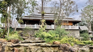 Il s’agit d’un bâtiment traditionnel doté d’une façade en pierre, d’une terrasse en bois et d’un jardin agrémenté d’une petite cascade et de rochers.