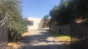 A paved driveway leading to a building with a white facade and a red roof. - Ahla Vert View (Sebaal)