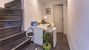 A staircase leading to a room with a desk, a chair, a small plant, and a framed picture on the wall. - Ad Maiora - Desing Rooms (Ragusa)