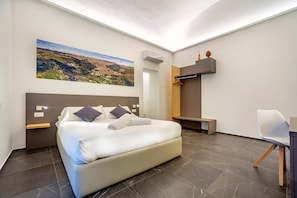 Ein modernes Schlafzimmer mit einem großen Bett, einem Schreibtisch und einem Sessel.
