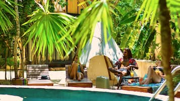 Una piscina al aire libre, sillones reclinables de piscina