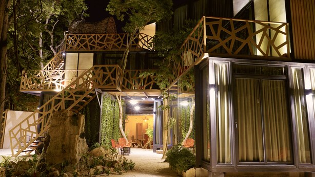 A multi-level outdoor structure with wooden railings and a seating area. - Bufo Alvarius (Tulum)