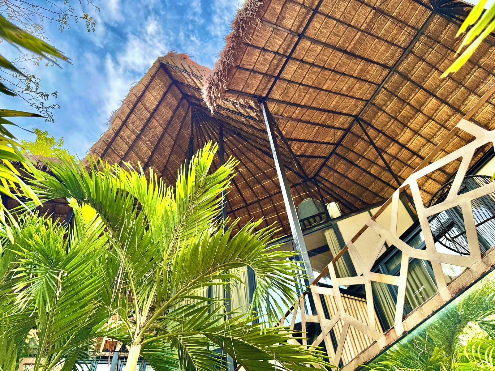 Un bâtiment doté d’un toit de chaume et d’une structure moderne aux motifs géométriques.