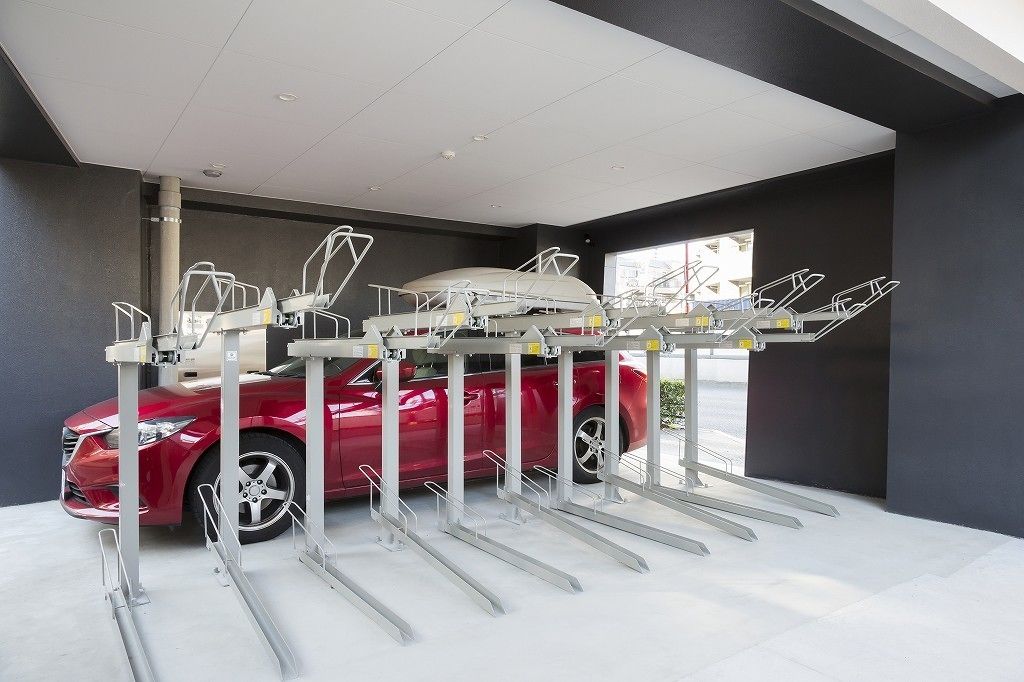 Une borne de recharge moderne pour voitures, avec une voiture rouge garée en dessous.