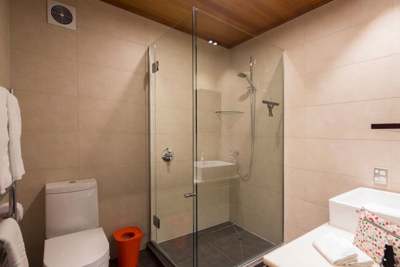 Une salle de bain moderne avec une douche à parois de verre, des toilettes et un lavabo.