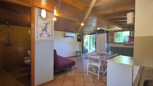 A wooden interior with a dining area, a purple sofa, and a tiled floor. - Lakeside cottage with private garden and pier. Pet-friendly.  (Oliveto Lario)