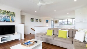 A modern living room with a flat-screen TV, a sofa set, and a coffee table. - Jinalong - Breathtaking Views (Angourie)