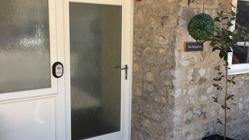 A stone building with a white door and a sign reading "The Bungalow".