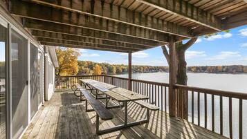 Une terrasse en bois avec des tables de pique-nique donnant sur un lac.