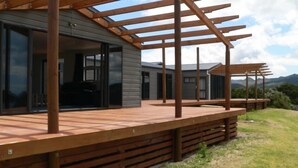 A modern house with a wooden deck and a pergola structure. - Private stunning elevated ocean veiws (Whangapoua)