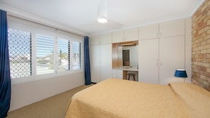 A bedroom with a bed, a desk, and a wardrobe. - Flinders Lodge - an idyllic holiday rental (Yamba)