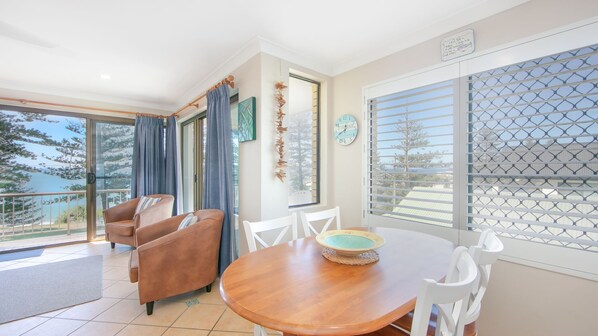 Enjoy a spacious room with a large window offering a view of the outdoors, a dining table, sofa, and comfortable seating area.